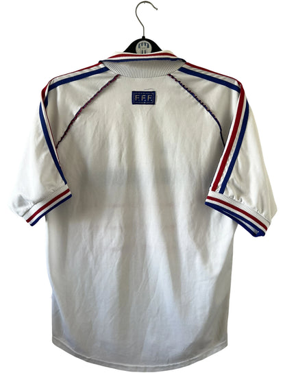 Maillot de foot vintage extérieur blanc de l'équipe de france 1998. On peut retrouver l'équipementier Adidas. Il s'agit d'un maillot authentique d'époque.