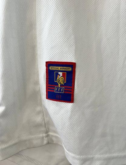 Maillot de foot vintage extérieur blanc de l'Equipe de France 1998. On peut retrouver l'équipementier Adidas. Il s'agit d'un maillot authentique d'époque.