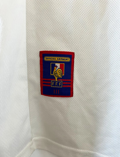 Maillot de foot vintage extérieur blanc de l'équipe de france 1998. On peut retrouver l'équipementier Adidas. Il s'agit d'un maillot authentique d'époque.