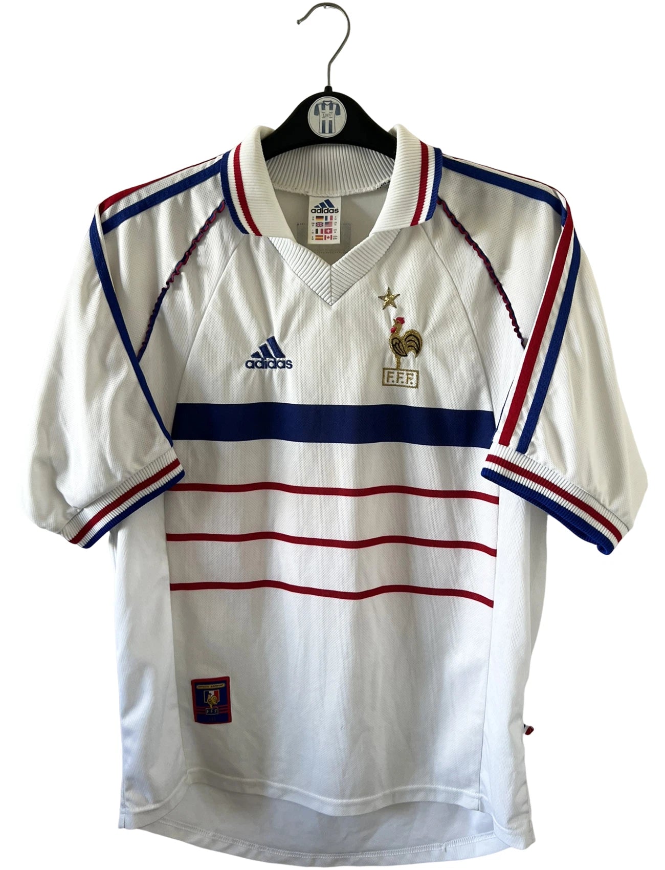Maillot de foot vintage extérieur blanc de l'équipe de france 1998. On peut retrouver l'équipementier Adidas. Il s'agit d'un maillot authentique d'époque.