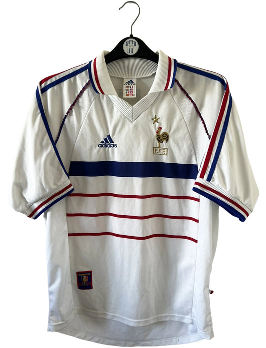 Maillot de foot vintage extérieur blanc de l'équipe de france 1998. On peut retrouver l'équipementier Adidas. Il s'agit d'un maillot authentique d'époque.