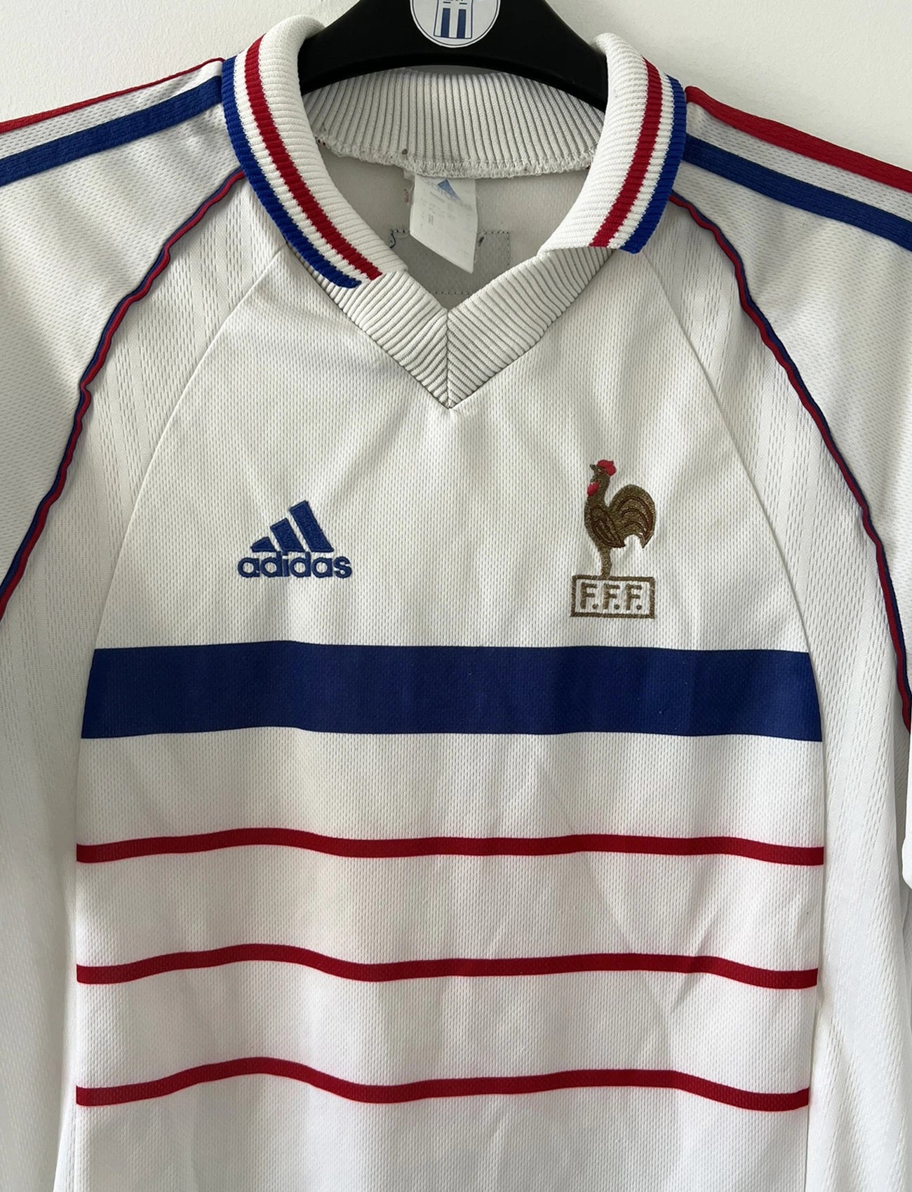 Maillot de foot vintage extérieur blanc de l'équipe de france 1998. On peut retrouver l'équipementier adidas. Il s'agit d'un maillot authentique d'époque.