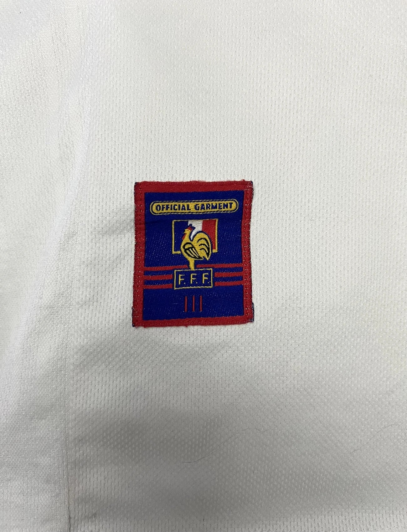 Maillot de foot vintage extérieur blanc de l'Equipe de France 1998. On peut retrouver l'équipementier Adidas. Il s'agit d'un maillot authentique d'époque.