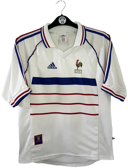 Maillot de foot vintage extérieur blanc de l'Equipe de France 1998. On peut retrouver l'équipementier Adidas. Il s'agit d'un maillot authentique d'époque.