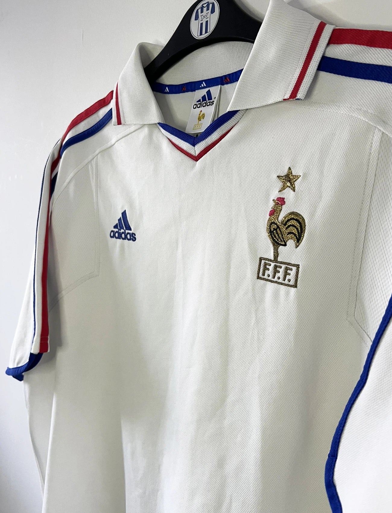 Maillot de foot vintage extérieur blanc de l'équipe de france 2000. On peut retrouver l'équipementier adidas. Il s'agit d'un maillot authentique d'époque comportant l'étiquette 647189.