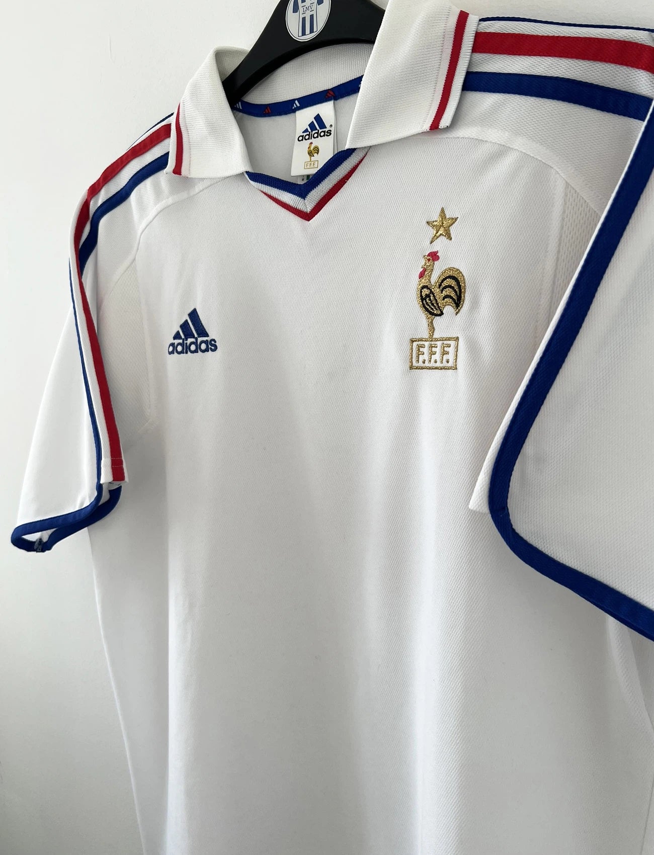 Maillot de foot vintage extérieur blanc de l'équipe de france 2000. On peut retrouver l'équipementier adidas. Il s'agit d'un maillot authentique d'époque comportant l'étiquette 647189.