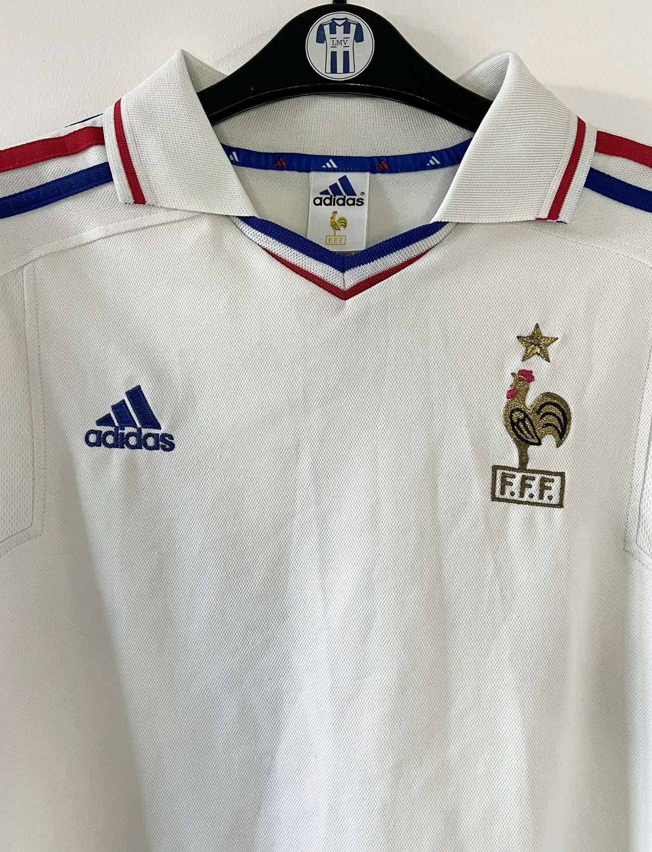 Maillot de foot vintage extérieur blanc de l'équipe de france 2000. On peut retrouver l'équipementier adidas. Il s'agit d'un maillot authentique d'époque comportant l'étiquette 647189.