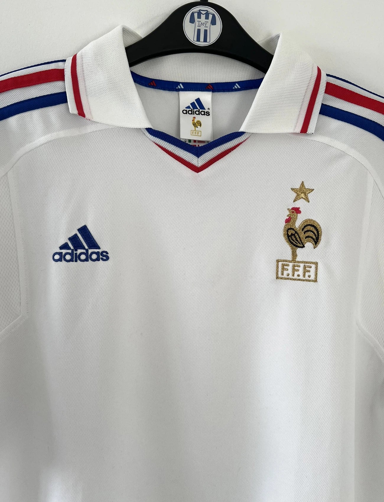 Maillot de foot vintage extérieur blanc de l'équipe de france 2000. On peut retrouver l'équipementier adidas. Il s'agit d'un maillot authentique d'époque comportant l'étiquette 647189.