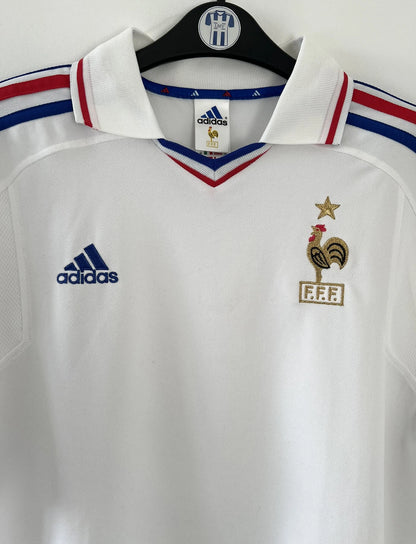 Maillot de foot vintage extérieur blanc de l'équipe de france 2000. On peut retrouver l'équipementier adidas. Il s'agit d'un maillot authentique d'époque comportant l'étiquette 647189.