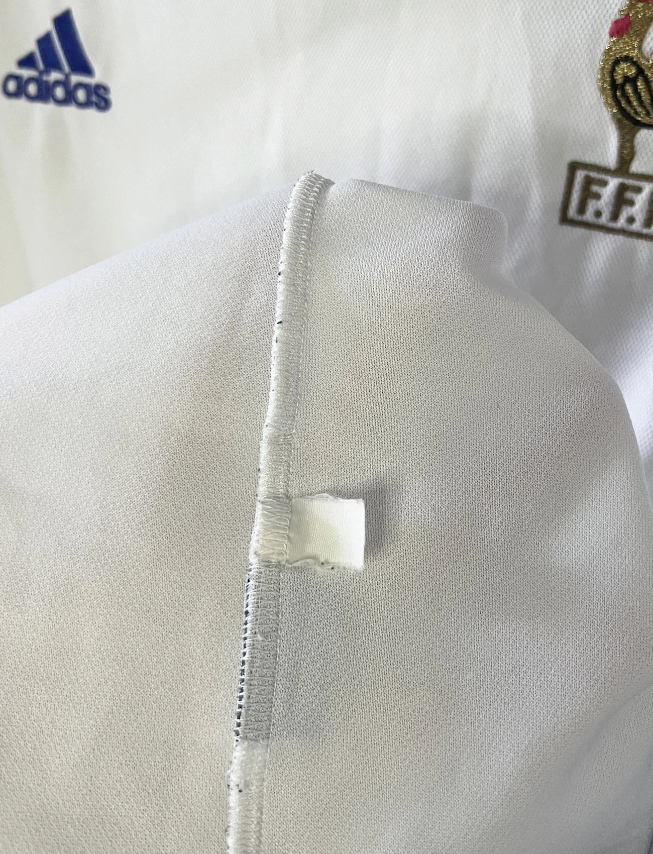 Maillot de foot vintage extérieur blanc de l'équipe de france 2000. On peut retrouver l'équipementier adidas. Il s'agit d'un maillot authentique d'époque comportant l'étiquette 647189.