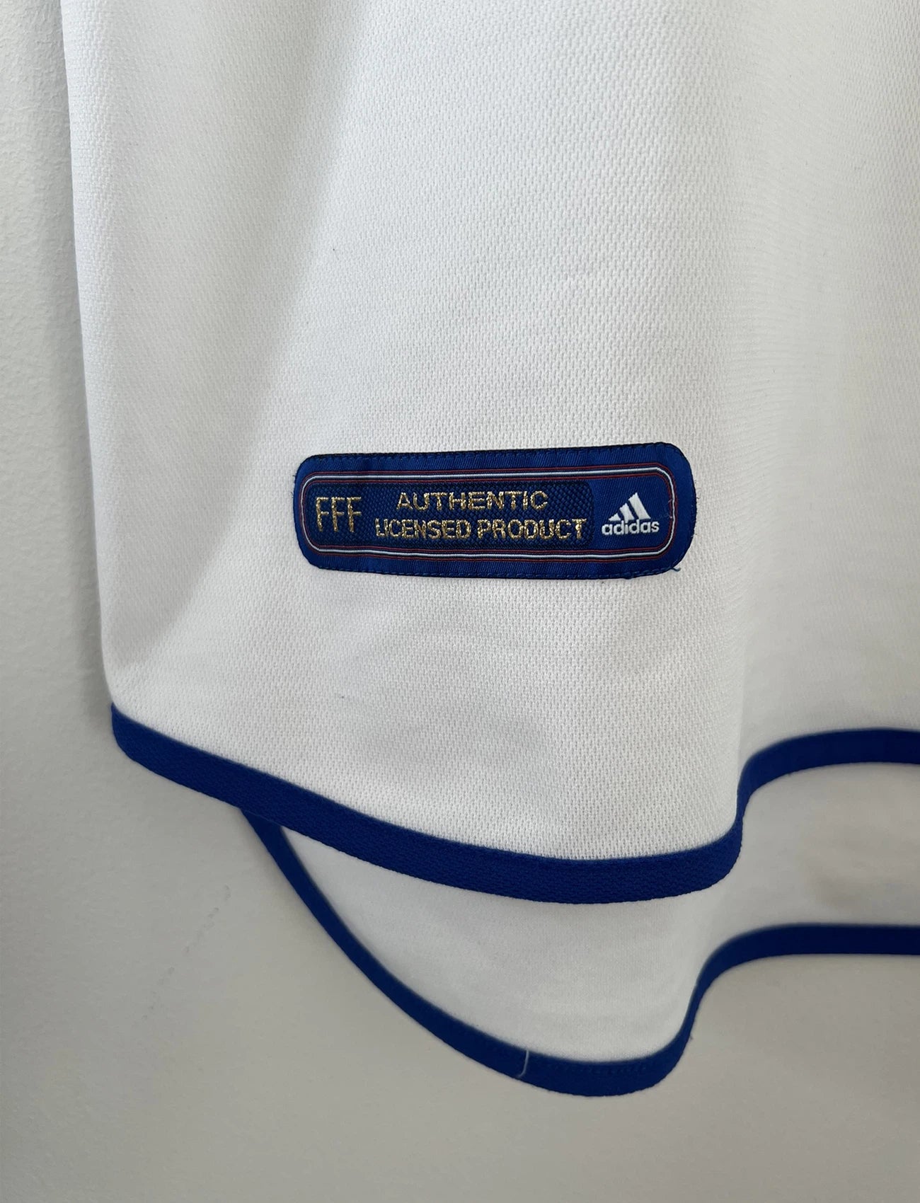 Maillot de foot vintage extérieur blanc de l'équipe de france 2000. On peut retrouver l'équipementier adidas. Il s'agit d'un maillot authentique d'époque comportant l'étiquette 647189.
