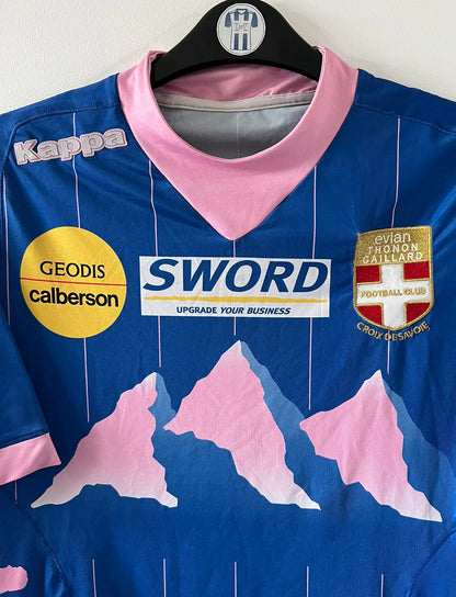 Maillot de foot vintage domicile bleu de l'Evian Thonon Gaillard 2012/2013. On peut retrouver l'équipementier Kappa et le sponsor Sword. Il s'agit d'un maillot authentique d'époque.