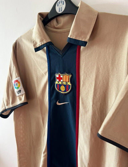 Maillot de foot vintage extérieur doré du FC Barcelone 2001/2002. On peut retrouver l'équipementier Nike. Il s'agit d'un maillot authentique d'époque.