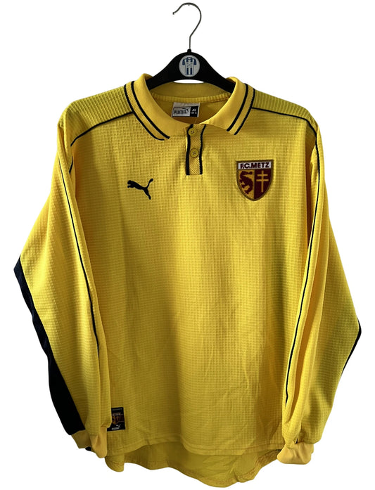 Maillot de foot vintage extérieur jaune du FC Metz de la saison 1999/2000. On peut retrouver l'équipementier Puma. Il s'agit d'un maillot authentique d'époque, issu du stock pro du FC Metz.
