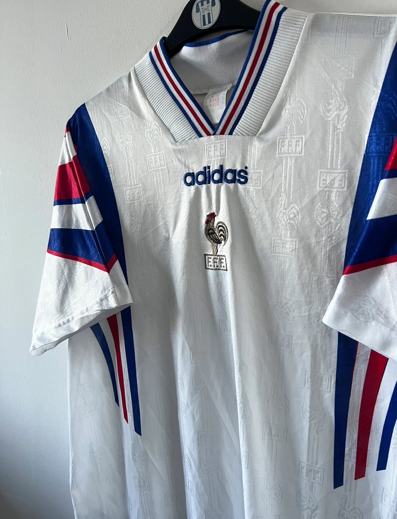 Maillot foot vintage domicile blanc de l'équipe de france 1996. On peut retrouver l'équipementier Adidas. Il s'agit d'un maillot authentique d'époque.