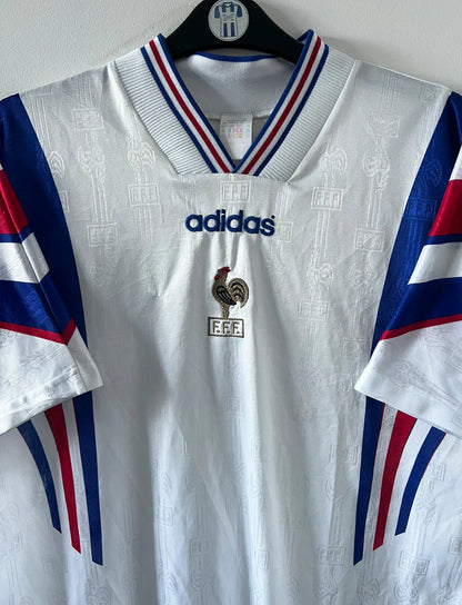 Maillot foot vintage domicile blanc de l'équipe de france 1996. On peut retrouver l'équipementier Adidas. Il s'agit d'un maillot authentique d'époque.