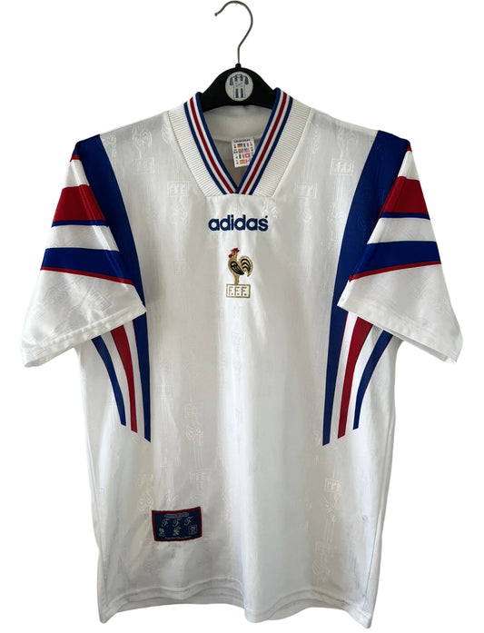 Maillot de foot vintage extérieur blanc de l'équipe de france 1996. On peut retrouver l'équipementier Adidas. Il s'agit d'un maillot authentique d'époque.