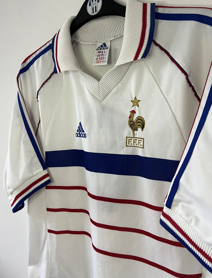 Maillot de foot vintage extérieur de l'équipe de france 1998 blanc. On peut retrouver l'équipementier adidas. Il s'agit d'un maillot authentique d'époque.