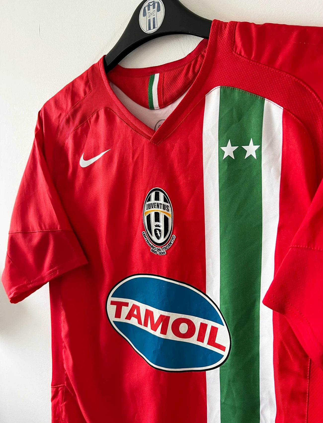 Maillot de foot vintage extérieur orange de la Juventus 2005/2006. On peut retrouver l'équipementier Nike et le sponsor Tamoil. Il s'agit du maillot du centenaire pour le premier scudetto. Il s'agit d'un maillot authentique d'époque.