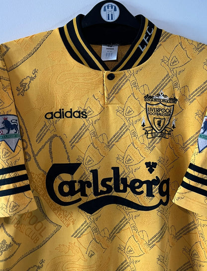 Maillot de foot vintage extérieur jaune de Liverpool de la saison 1994/1996. On peut retrouver l'équipementier Adidas et le sponsor Carlsberg. Il s'agit d'un maillot authentique d'époque.