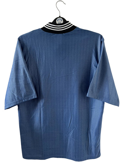 Maillot de foot vintage extérieur bleu de Newcastle de la saison 1996/1997. On peut retrouver l'équipementier Adidas et le sponsor Newcastle Brown Ale. Il s'agit d'un maillot authentique d'époque.