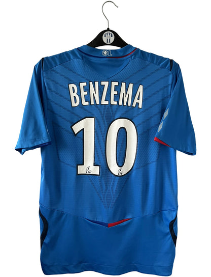 Maillot foot vintage extérieur bleu de l'OL saison 2008/2009. On peut retrouver l'équipementier Umbro et le sponsor Ticket. Il s'agit d'un maillot authentique d'époque.