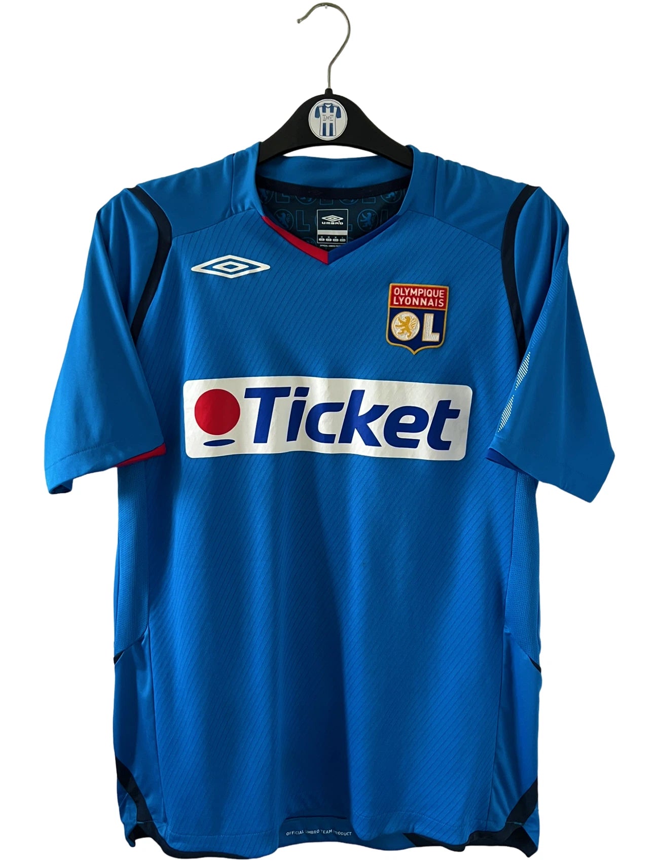 Maillot foot vintage extérieur bleu de l'OL saison 2008/2009. On peut retrouver l'équipementier Umbro et le sponsor Ticket. Il s'agit d'un maillot authentique d'époque.