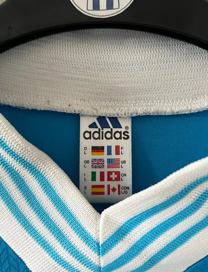 Maillot de foot vintage extérieur bleu de l'OM de la saison 1997/1998. On peut retrouver l'équipementier Adidas et le sponsor Ericsson. Il s'agit d'un maillot authentique d'époque.