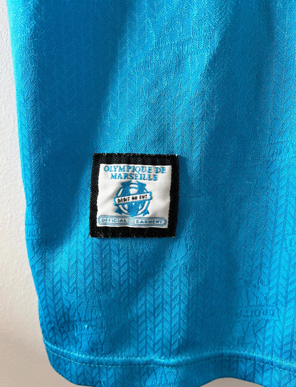 Maillot de foot vintage bleu extérieur de l'OM 1997/1998. On peut retrouver l'équipementier Adidas et le sponsor Ericsson. Il s'agit d'un maillot authentique d'époque.