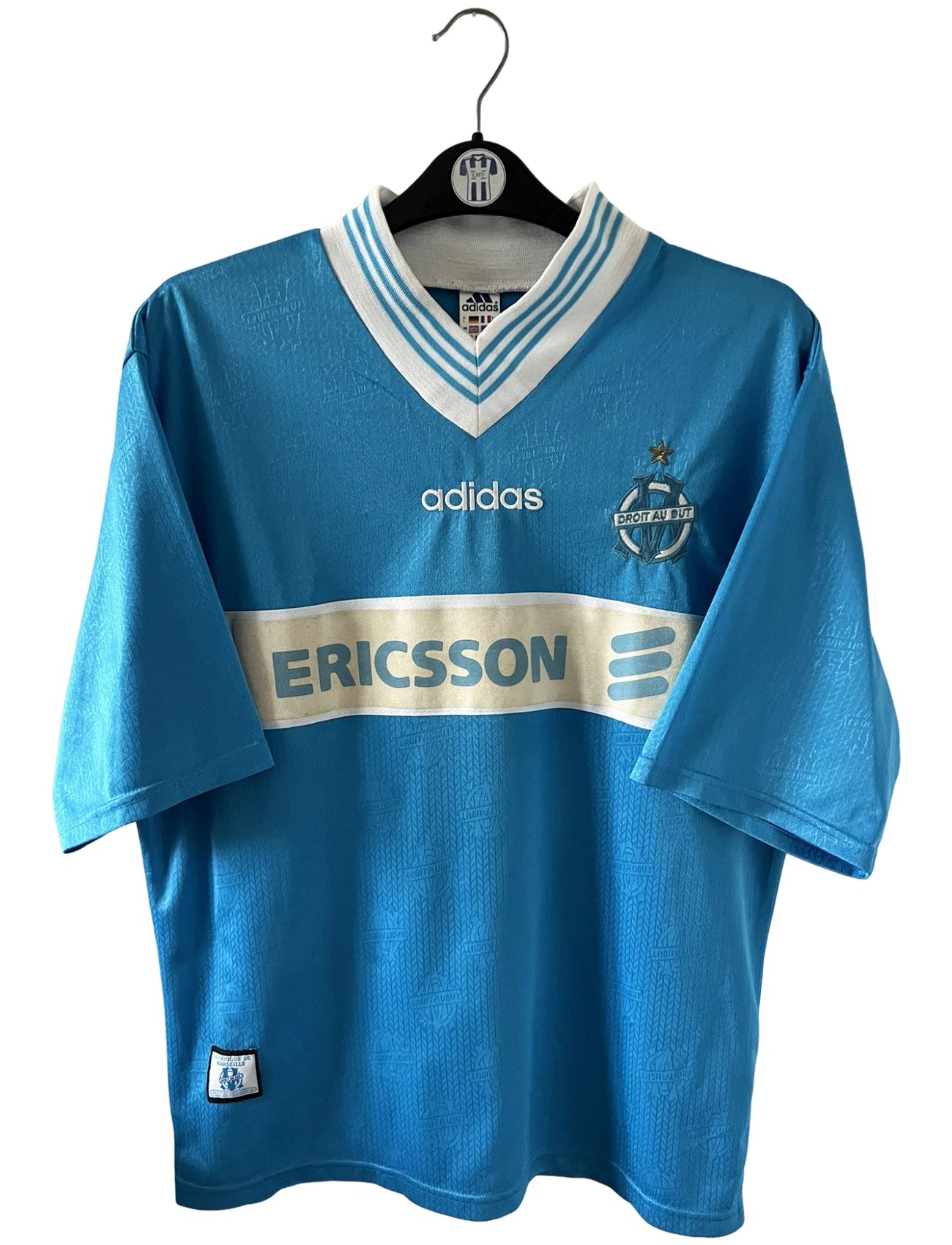 Maillot de foot vintage extérieur bleu de l'OM de la saison 1997/1998. On peut retrouver l'équipementier Adidas et le sponsor Ericsson. Il s'agit d'un maillot authentique d'époque.