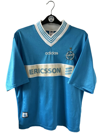 Maillot de foot vintage extérieur bleu de l'OM de la saison 1997/1998. On peut retrouver l'équipementier Adidas et le sponsor Ericsson. Il s'agit d'un maillot authentique d'époque.
