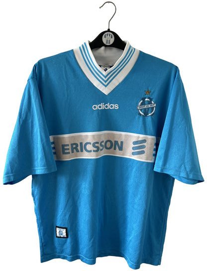 Maillot de foot vintage bleu extérieur de l'OM 1997/1998. On peut retrouver l'équipementier Adidas et le sponsor Ericsson. Il s'agit d'un maillot authentique d'époque.