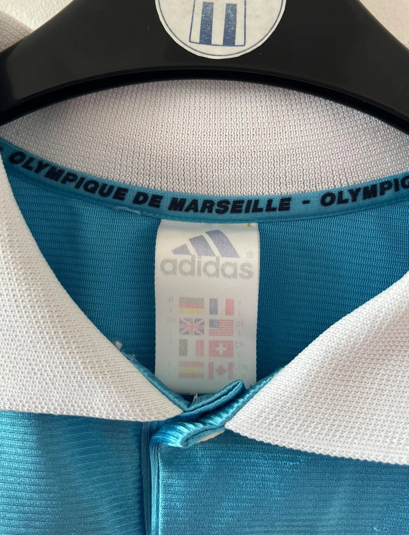 Maillot de foot vintage extérieur bleu de l'OM 1998. On peut retrouver l'équipementier Adidas et le sponsor Ericsson. Il s'agit d'un maillot authentique d'époque.