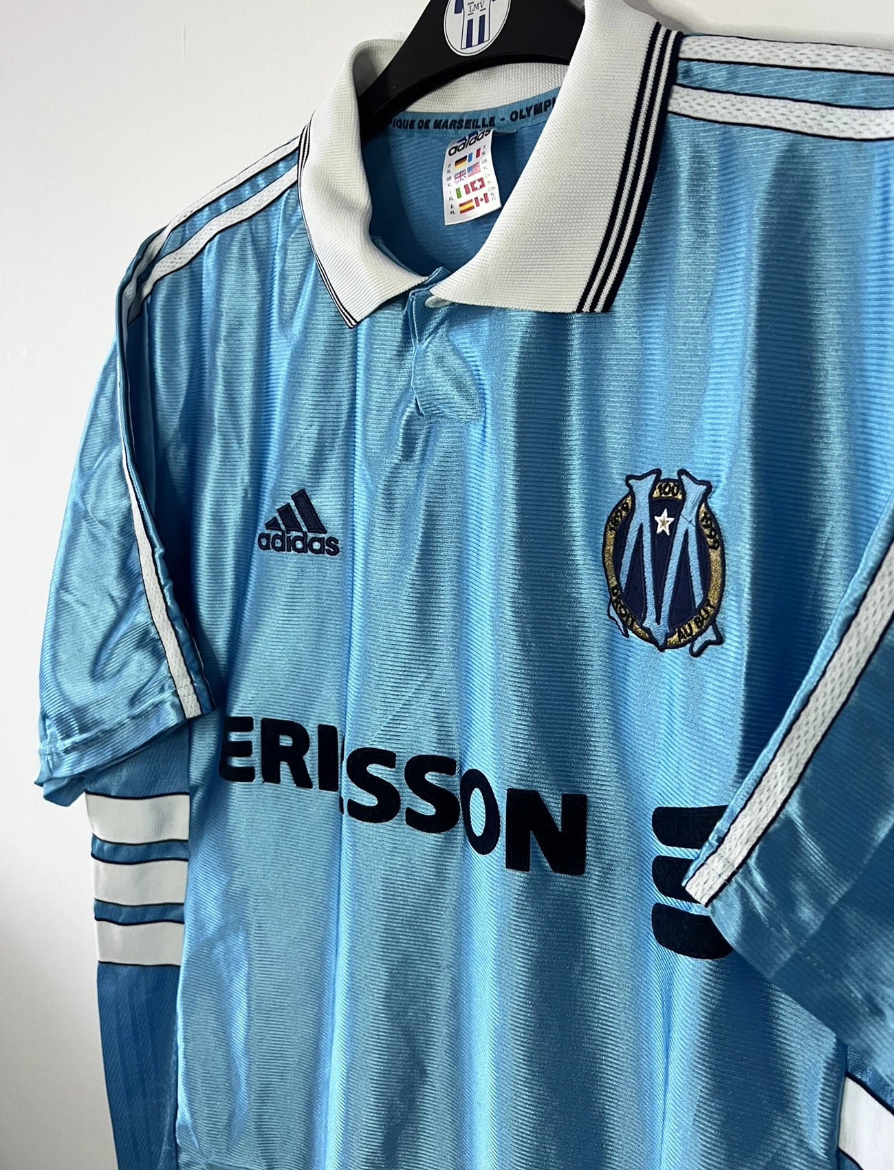 Maillot de foot vintage extérieur bleu de l'Olympique de Marseille de la saison 1998/1999. On peut retrouver l'équipementier Adidas et le sponsor Ericsson. Il s'agit d'un maillot authentique d'époque.