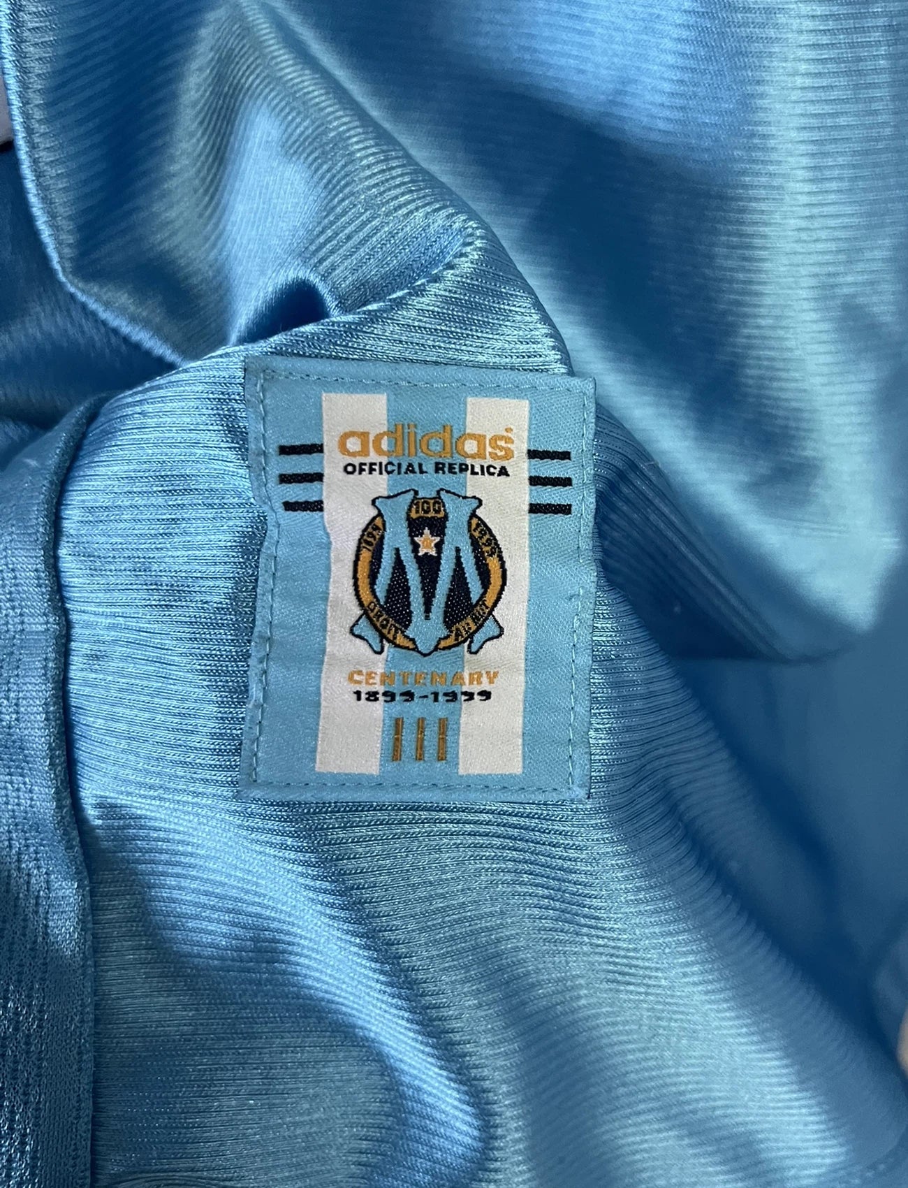 Maillot de foot vintage extérieur bleu de l'Olympique de Marseille de la saison 1998/1999. On peut retrouver l'équipementier Adidas et le sponsor Ericsson. Il s'agit d'un maillot authentique d'époque.