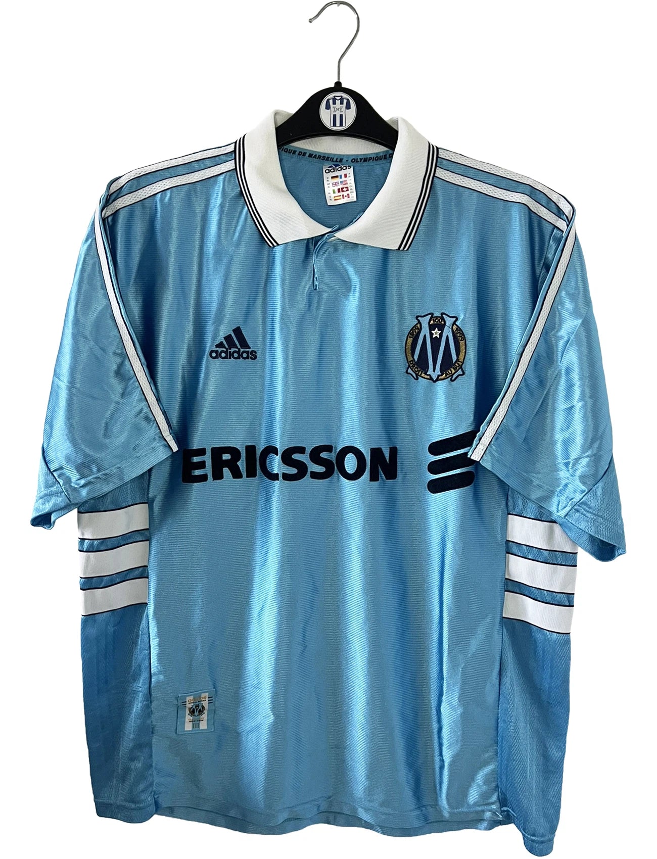 Maillot de foot vintage extérieur bleu de l'Olympique de Marseille de la saison 1998/1999. On peut retrouver l'équipementier Adidas et le sponsor Ericsson. Il s'agit d'un maillot authentique d'époque.