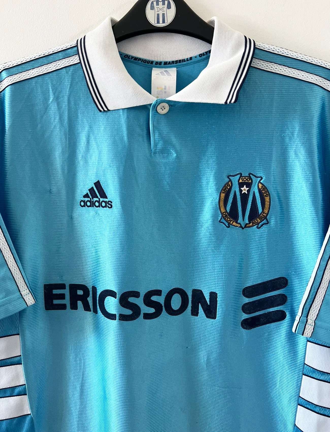Maillot de foot vintage extérieur bleu de l'OM 1998/1999. On peut retrouver l'équipementier Adidas et le sponsor Ericsson. Il s'agit d'un maillot authentique d'époque.