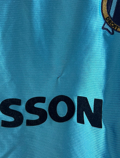 Maillot de foot vintage extérieur bleu de l'OM 1998. On peut retrouver l'équipementier Adidas et le sponsor Ericsson. Il s'agit d'un maillot authentique d'époque.