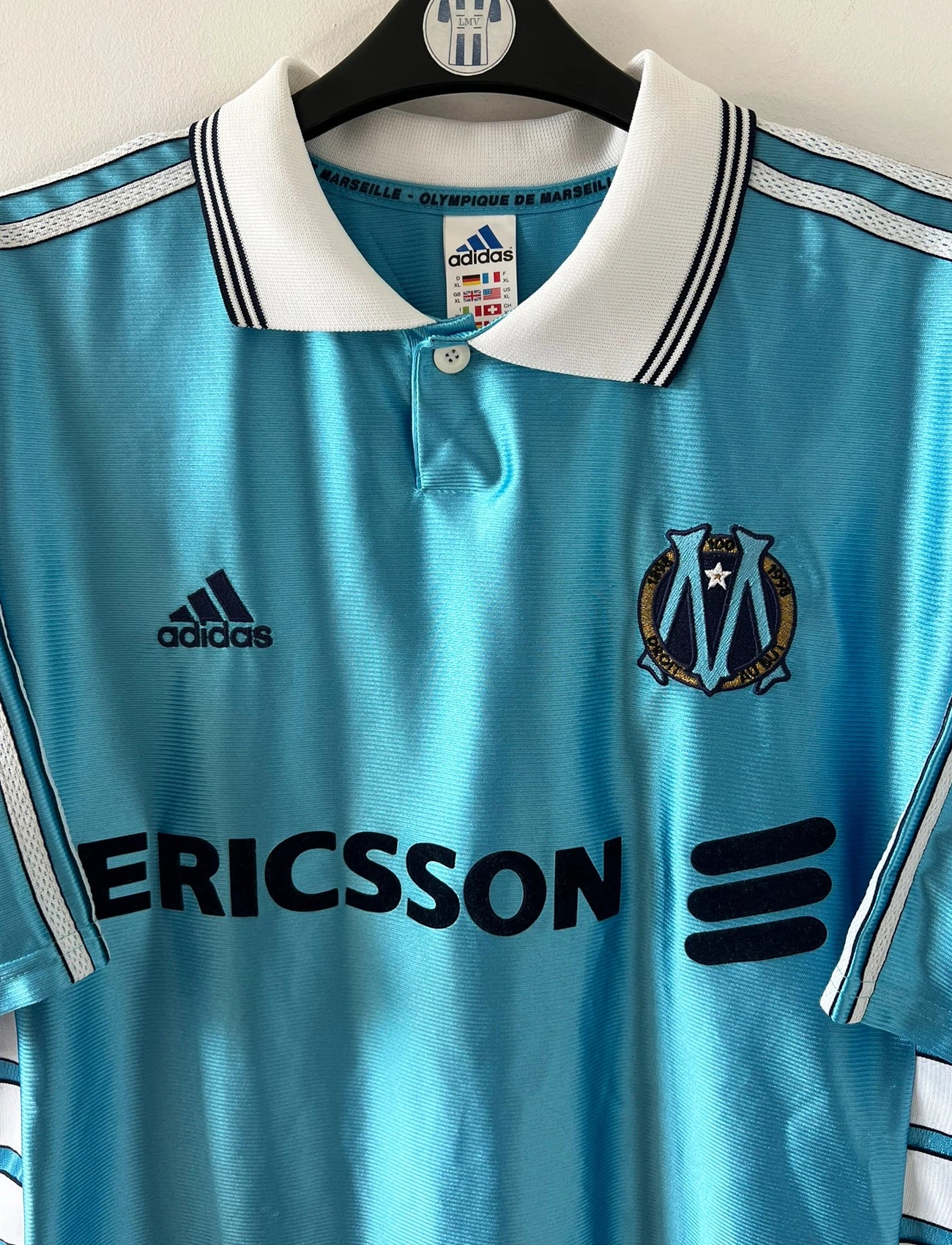 Maillot de foot vintage bleu de l'OM 1998/1999 du centenaire. On peut retrouver l'équipementier Adidas et le sponsor Ericsson. Il s'agit d'un maillot authentique d'époque.