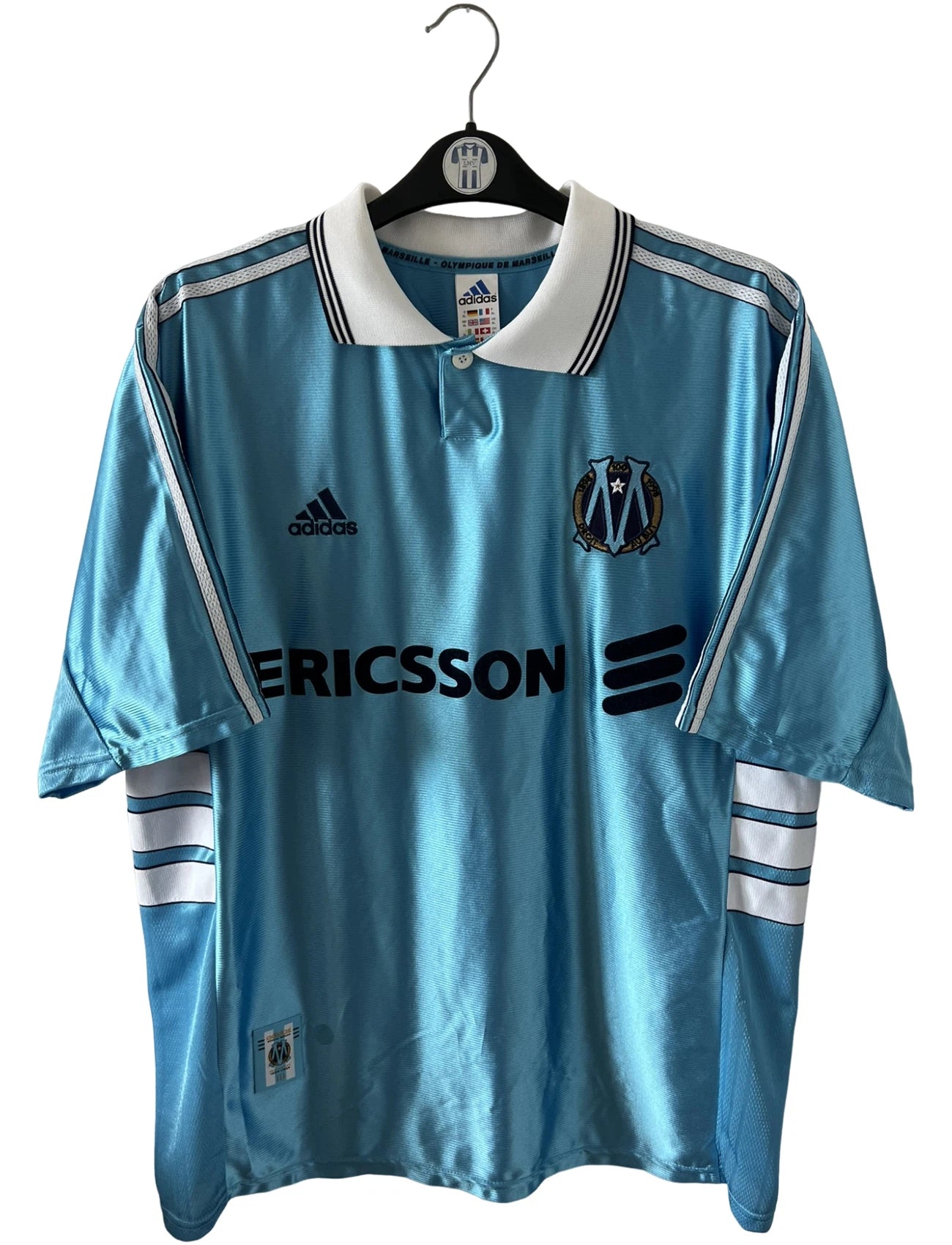 Maillot de foot vintage bleu de l'OM 1998/1999 du centenaire. On peut retrouver l'équipementier Adidas et le sponsor Ericsson. Il s'agit d'un maillot authentique d'époque.