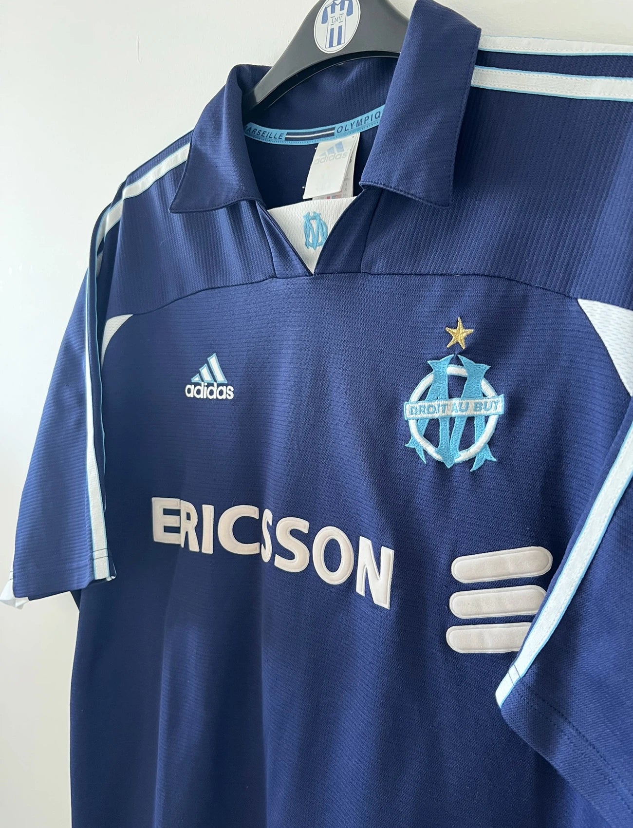 Maillot de foot vintage extérieur bleu de l'OM de la saison 1999/2000. On peut retrouver l'équipementier Adidas et le sponsor Ericsson. Il s'agit d'un maillot authentique d'époque.