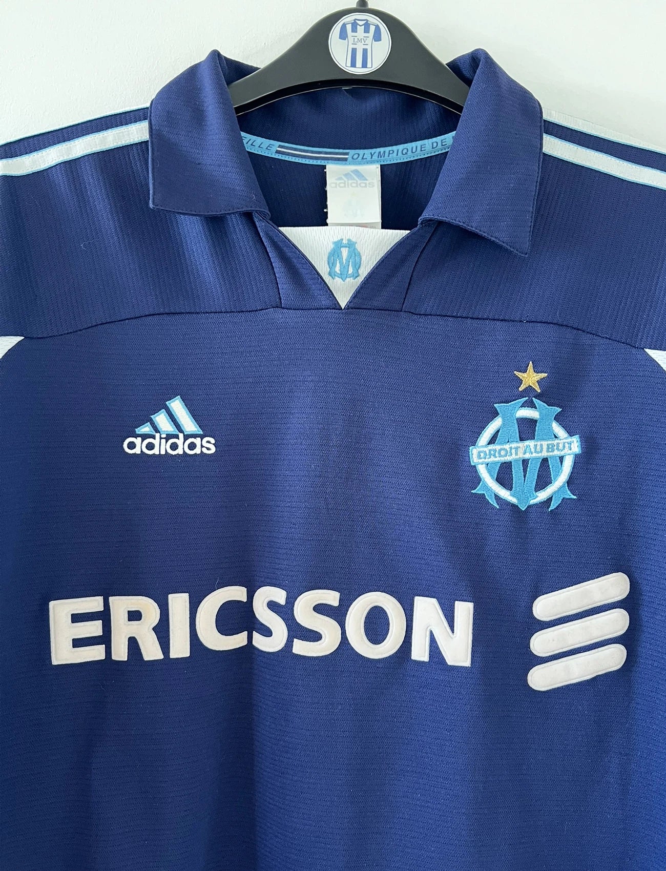 Maillot de foot vintage extérieur bleu de l'OM de la saison 1999/2000. On peut retrouver l'équipementier Adidas et le sponsor Ericsson. Il s'agit d'un maillot authentique d'époque.