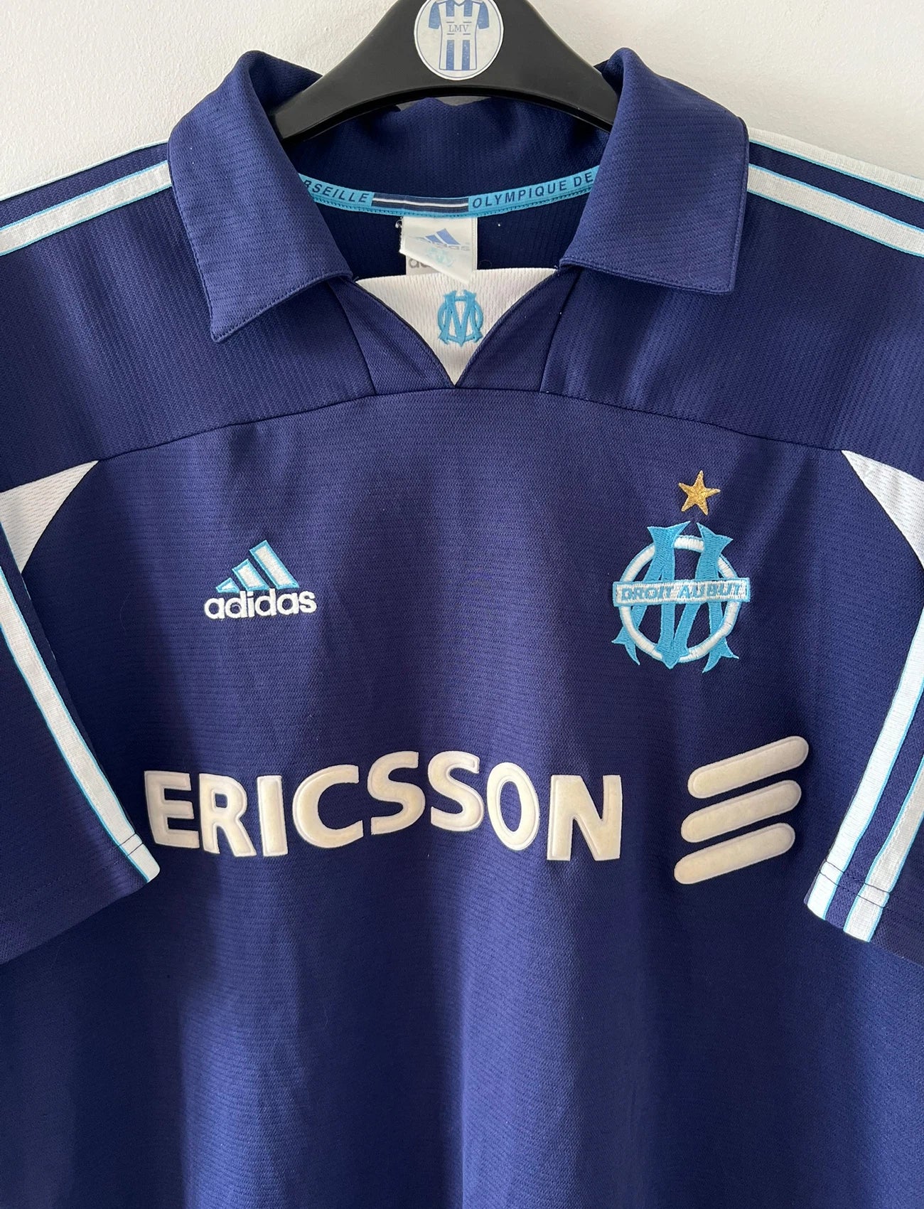 Maillot de foot vintage bleu de l'OM 1999/2000. On peut retrouver l'équipementier Adidas et le sponsor Ericsson. Il s'agit d'un maillot authentique d'époque.