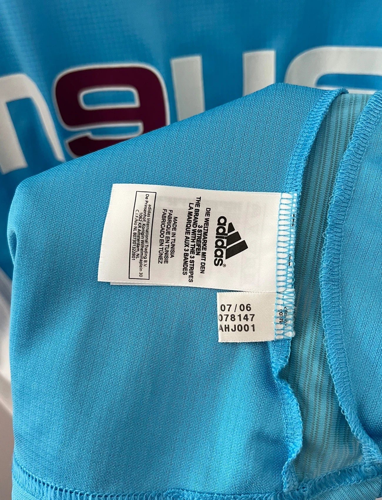 Maillot de foot vintage extérieur bleu et blanc de l'OM 2006/2007. On peut retrouver l'équipementier Adidas et le sponsor Neuf. Le maillot est floqué du numéro 7 Franck Ribery. Il s'agit d'un maillot authentique d'époque.