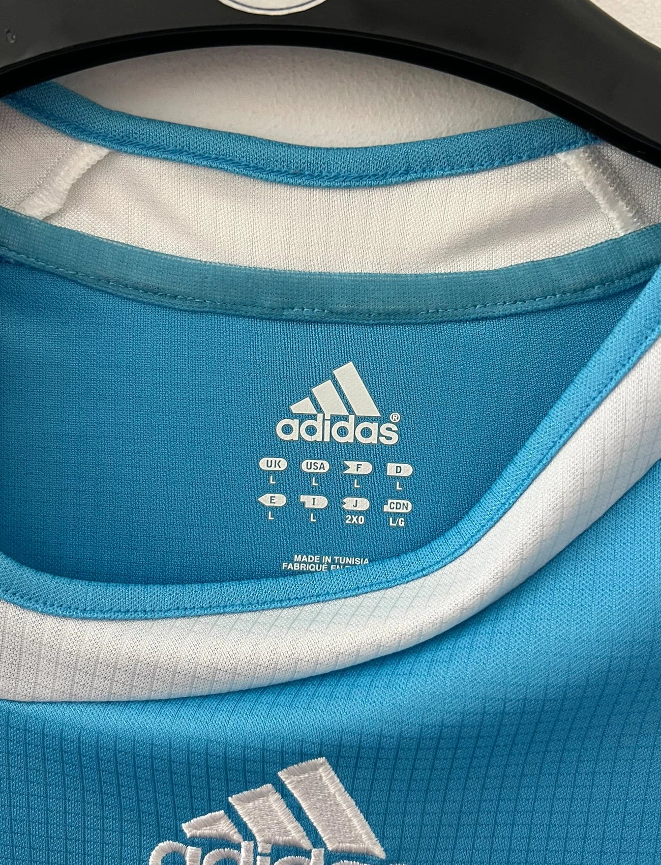 Maillot de foot vintage extérieur bleu et blanc de l'OM 2006/2007. On peut retrouver l'équipementier Adidas et le sponsor Neuf. Le maillot est floqué du numéro 7 Franck Ribery. Il s'agit d'un maillot authentique d'époque.