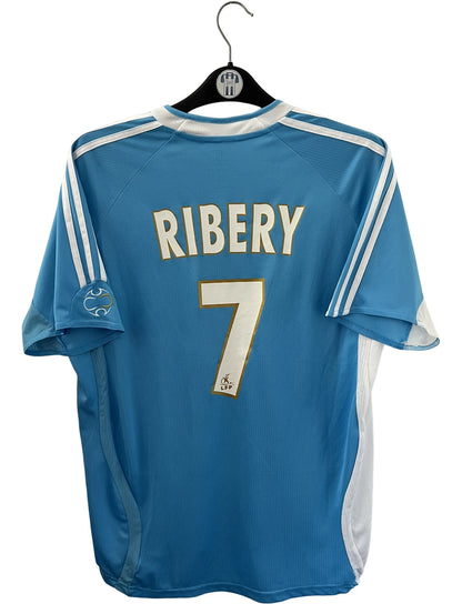 Maillot de foot vintage extérieur bleu et blanc de l'OM 2006/2007. On peut retrouver l'équipementier Adidas et le sponsor Neuf. Le maillot est floqué du numéro 7 Franck Ribery. Il s'agit d'un maillot authentique d'époque.