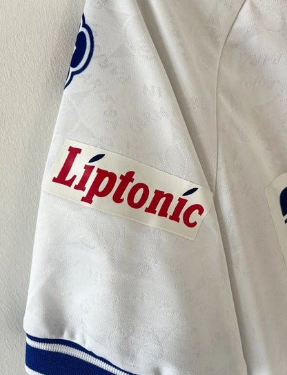 Maillot de foot vintage extérieur blanc du PSG 1994/1995. On peut retrouver l'équipementier Nike et les sponsors Seat, Tourtel et Liptonic. Il s'agit d'un maillot authentique d'époque.