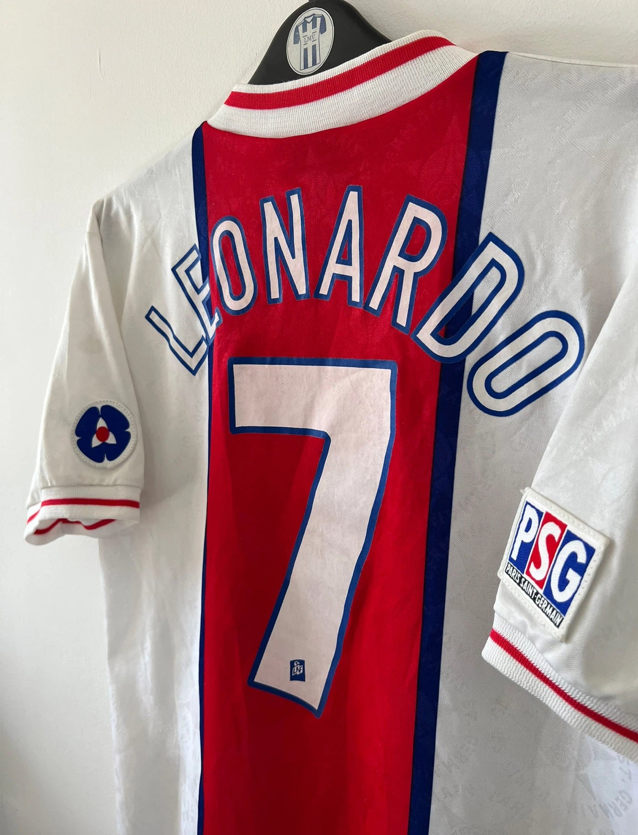 Maillot de foot vintage extérieur blanc et rouge du PSG 1995/1996. On peut retrouver l'équipementier Nike et le sponsor Opel. Le maillot est floqué du numéro 7 Leonardo. Il s'agit d'un maillot authentique d'époque. 