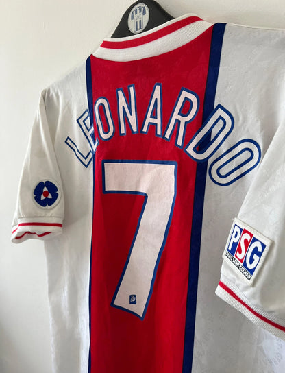 Maillot de foot vintage extérieur blanc et rouge du PSG 1995/1996. On peut retrouver l'équipementier Nike et le sponsor Opel. Le maillot est floqué du numéro 7 Leonardo. Il s'agit d'un maillot authentique d'époque. 