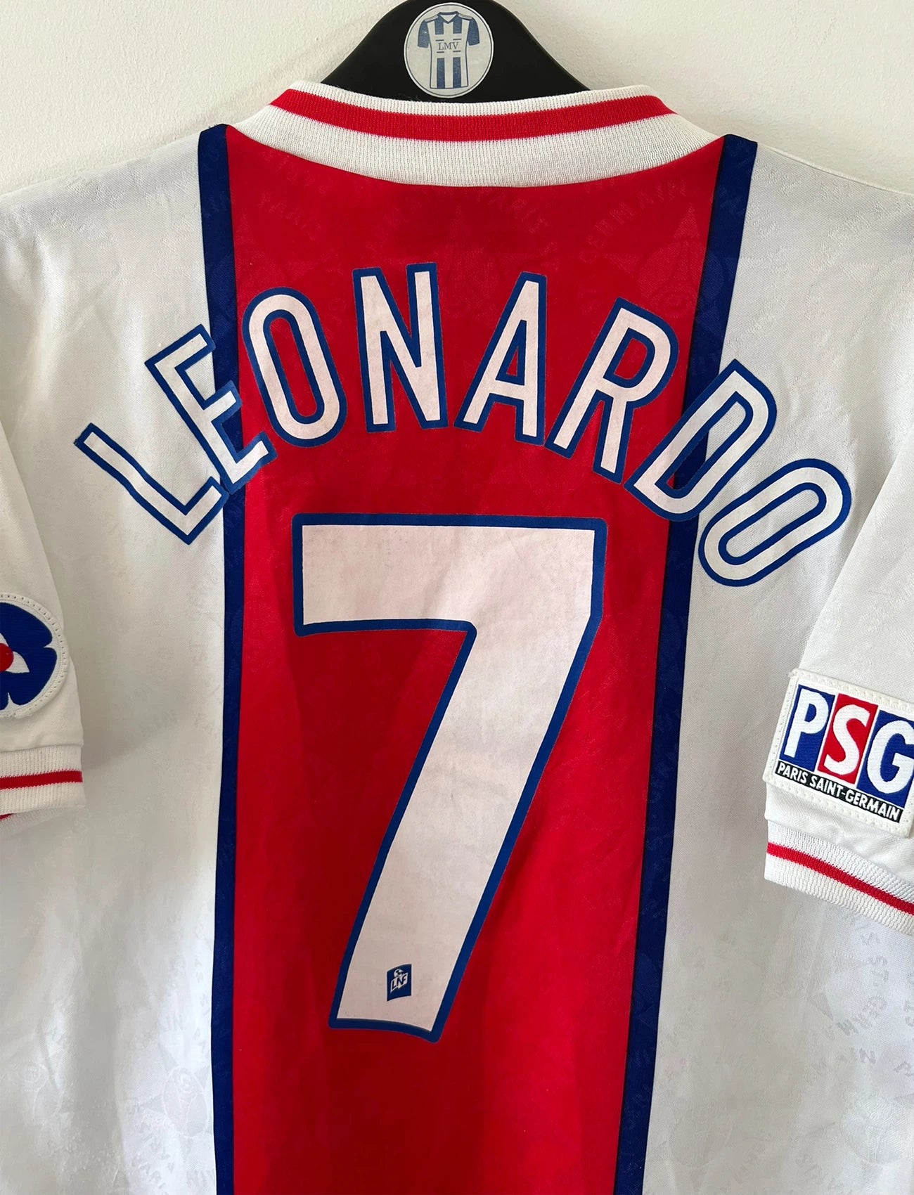 Maillot de foot vintage extérieur blanc et rouge du PSG 1995/1996. On peut retrouver l'équipementier Nike et le sponsor Opel. Le maillot est floqué du numéro 7 Leonardo. Il s'agit d'un maillot authentique d'époque. 